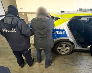 Policjant z zatrzymanym mężczyzną.