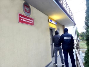 Policjant wprowadza mężczyznę do Posterunku Policji w Skarszewach.