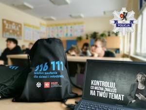 Młodzież szkolna oraz plecaki wręczane w ramach projektu edukacyjnego pod nazwą Bezpieczny Nastolatek w Świecie Cyfrowym.