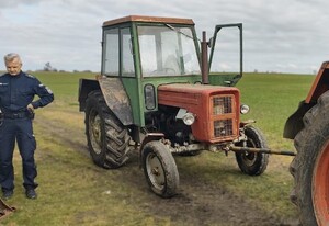 Policjant i odnaleziony ciągnik rolniczy.