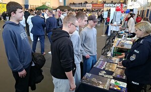 Policjantka rozmawia z młodzieżą w czasie Powiatowych Targów Edukacyjnych.