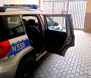 Zatrzymany mężczyzna siedzi w radiowozie.