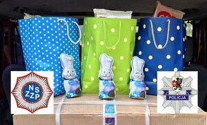 Torebki ze słodyczami, nowa pralka w kartonie oraz logo starogardzkiej komendy oraz policyjnych związków zawodowych.