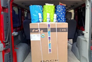 Torebki ze słodyczami, nowa pralka w kartonie oraz logo starogardzkiej komendy oraz policyjnych związków zawodowych.