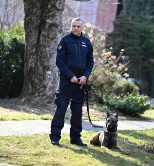 Policjant z psem pozują do zdjęcia.