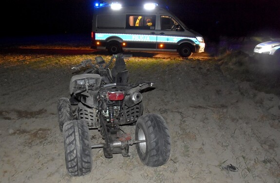 Zatrzymany Quad, a w tle radiowóz z włączonymi światłami błyskowymi.