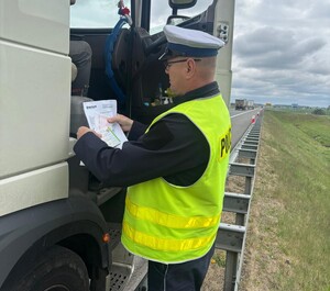 Policjant w trakcie kontroli ciężarówki.