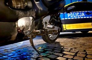 Motocykl i oznakowany radiowóz policyjny.