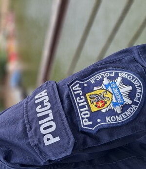 Prawe ramię policjanta, biały napis Policja oraz naszywka z logiem Komendy Powiatowej Policji w Starogardzie Gdańskim.