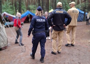 Mundurowi spacerują po terenie obozowiska.