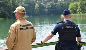 Policjanci i strażacy w czasie kontrolowania kompieliska.