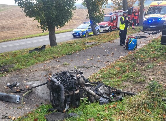 Policjantka podczas oględzin rozbitego audi na miejscu kolizji.